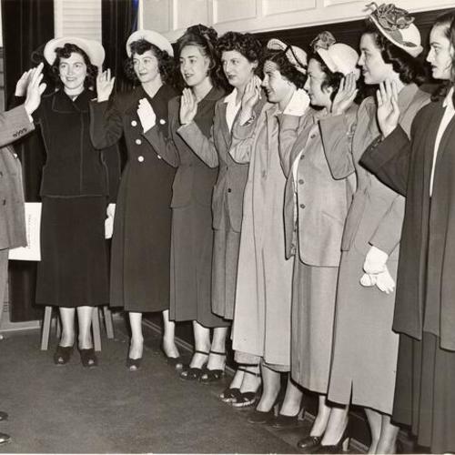 [Genevieve M. Bayreuther, Mary Theresa Loftus, Virginia M. Cullen, Claire E. Lutz, Shirley M. Schreff, Margaret J. Spraggins, Margaret A. Dolan and Dorothy M. Boughton taking their oath in front of Police Chief Michael Mitchell as protective officers at S