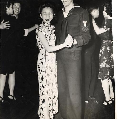 [Men and women dancing at a social gathering in Chinatown]