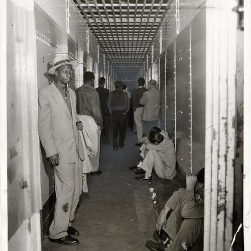 [Narrow corridor being used as jail dining room and recreation area in Old Hall of Justice]