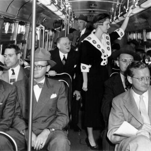 [Mayor Elmer E. Robinson and Jean St. Clair, "Miss Modern Transportation," riding on a bus]