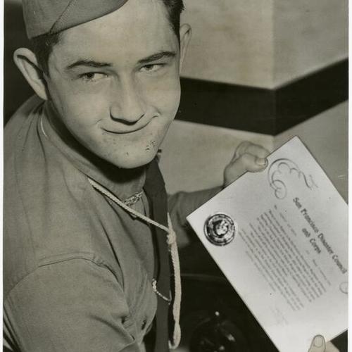 [Boy Scout Glenn Brouilette holds a certificate of completion from the San Francisco Disaster Council and Corps]