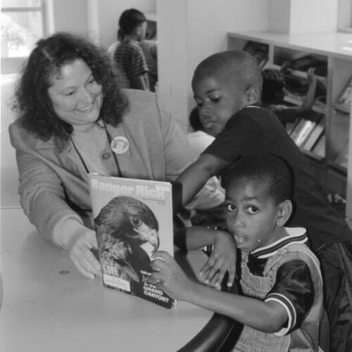 Librarian Kathy Hunsicker and two African American boys in the Fisher Children's Center of the San Francisco Public Library