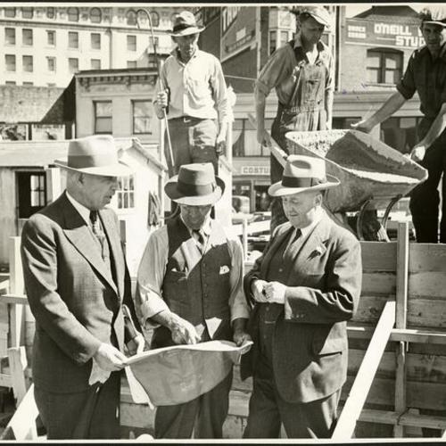 [Alexander Watchman, Joseph Stuart and Dr. Howard M. McKinley standing together on the site of Hospitality House]