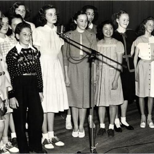 [Dianne Goldman at the microphone with other contestants during The News San Francisco Spelling Bee finals]