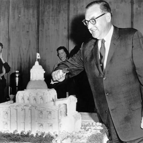[Governor Edmund G. Brown cuts cake at a birthday party in his office]