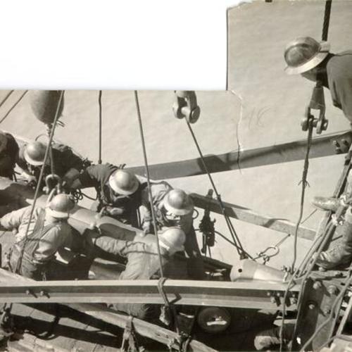 [Bridge workers driving the last pin into place on the cantilever span of the San Francisco-Oakland Bay Bridge]