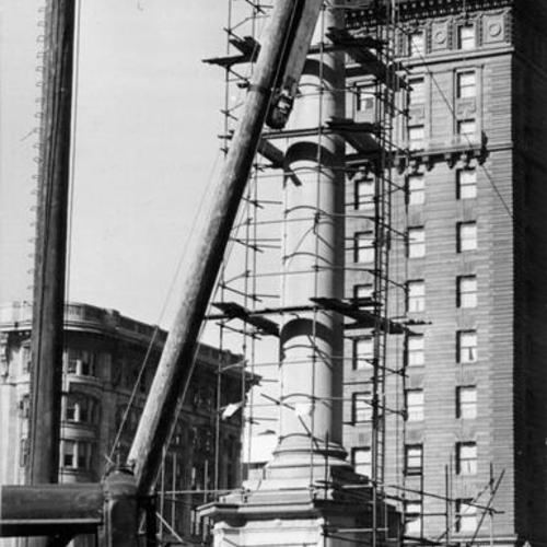 ["Victory" being lowered from the top of the Dewey Monument by workmen preparing the site for an underground garage]