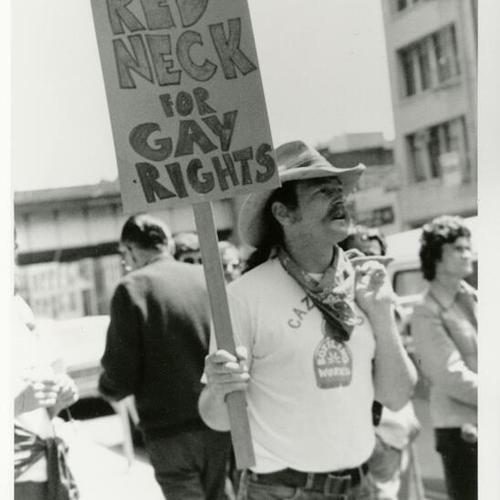 [A man carrying a sign during Pride Parade]