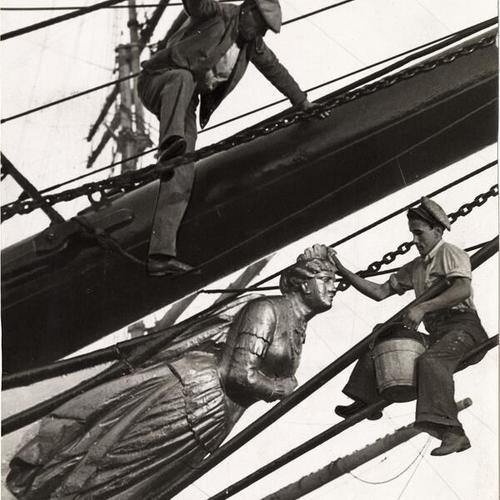 [Two men washing the figurehead on the sailing ship "Pacific Queen" (also known as the "Balclutha")]