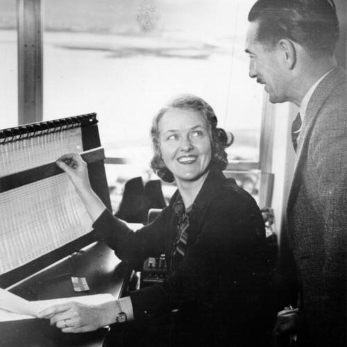 [San Francisco-Oakland Bay Bridge administration building clerk Mary Brockman shows J. R. Warme the tally of vehicle crossings for the first year]