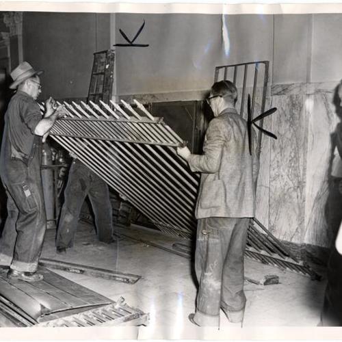 [Workers pulling down a section of the prisoners cage in Old Hall of Justice]