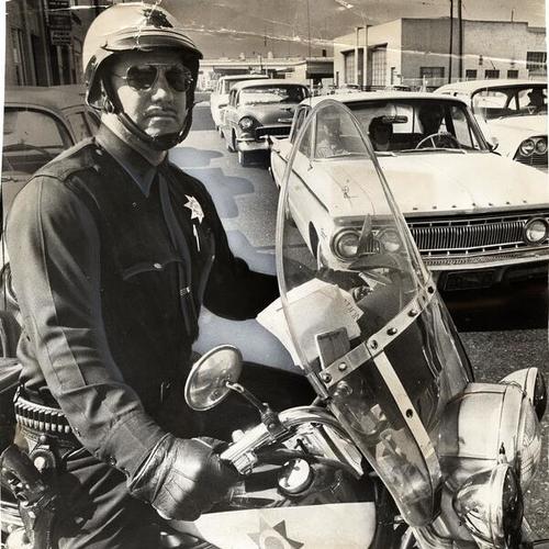 [Policeman Tony Salido observing city traffic from his motorcycle]