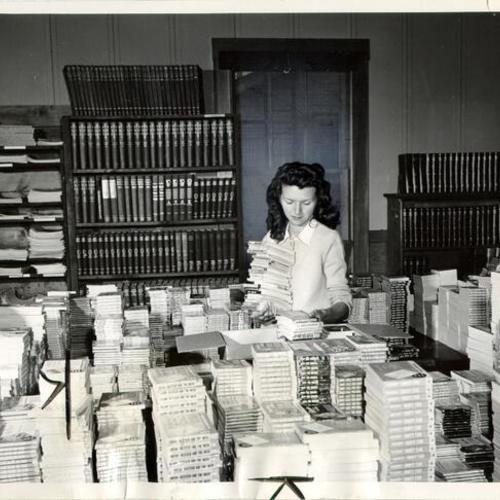 [Mrs. Elvie Schriebman, secretary at Sixth Army Library Depot, packing a case of books for shipment to troops in Korea]