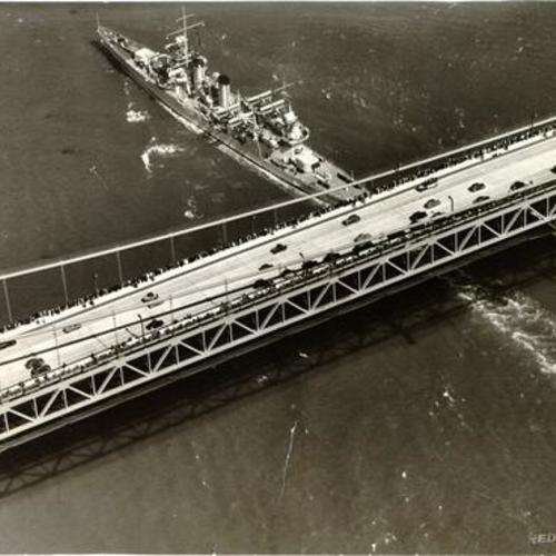 [Aerial view of a ship passing underneath the Golden Gate Bridge]