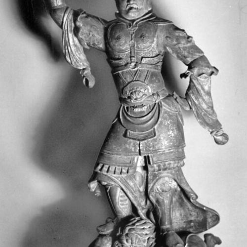 [Japanese wood sculpture of Tamon-Ten, temple guardian, standing on two crouched devils from the Brundage Art Collection at the De Young Museum in Golden Gate Park]