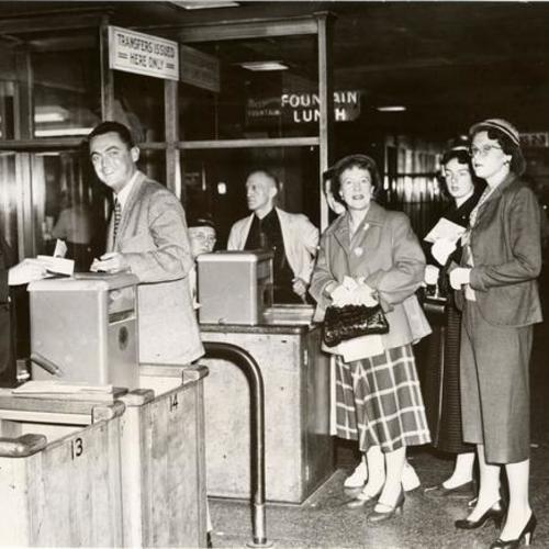 [George Plein collecting fares from passengers at Bay Bridge transit terminal]