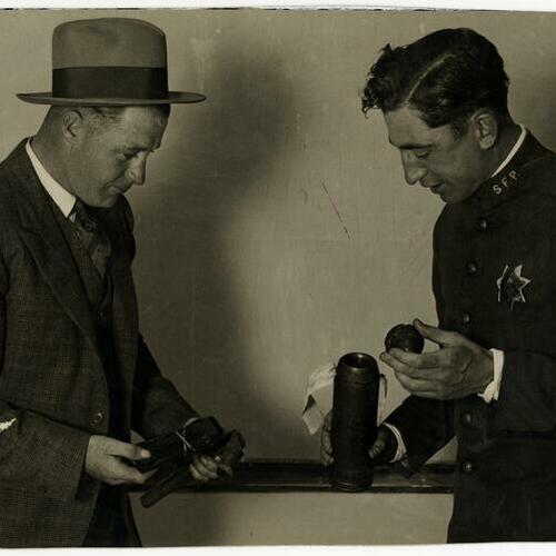Detective Sergeant John Gleason and officer John McArdle examining portions of exploded bomb