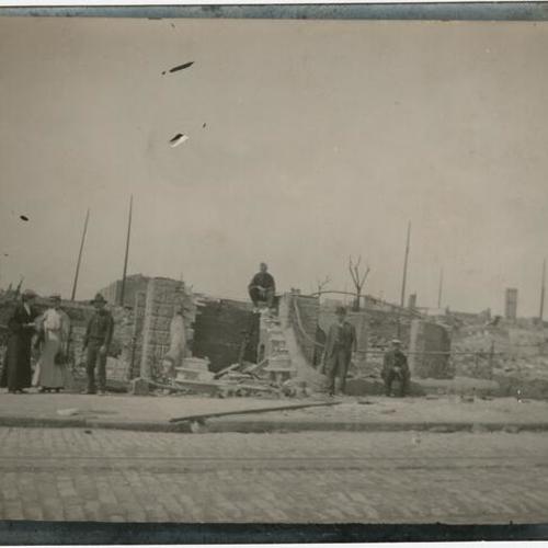 [Group of people posing by ruins on Sacramento Street, near Polk]