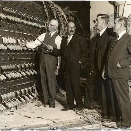 [Four men examining the electrical switchboard at the War Memorial Opera House]