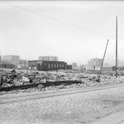 [Ruins from 1906 earthquake, streetcar passes behind Newsom & Newsom Architects]