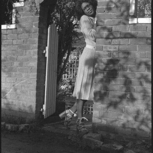 Sylvester standing under brick archway outdoors at Peter Mintun's house, Mountain View