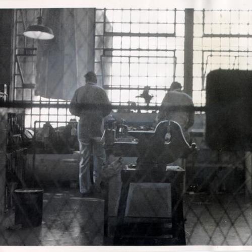 [Two prisoners working in the Alcatraz machine shop]