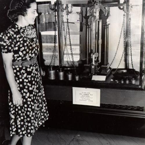 [Isabel Alison looking at scales on display at the Bank of California]