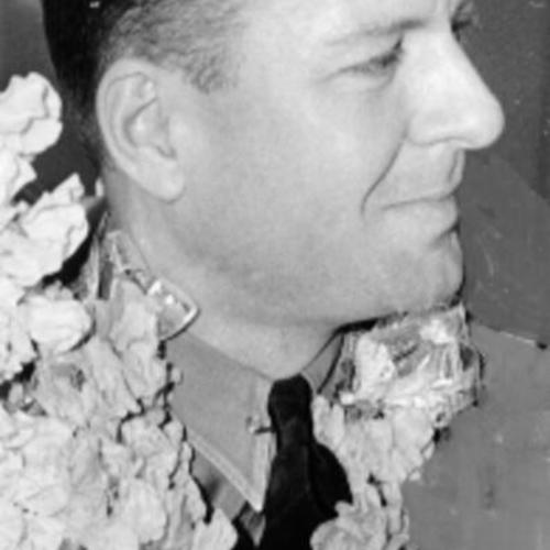 [Lucius Beebe pictured in a flower garland]