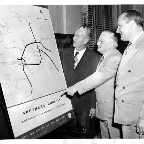 [Mayor Clifford E. Rishell of Oakland, Mayor Elmer E. Robinson of San Francisco, and Senator William F. Knowland of California examining plan of Southern Crossing Bridge]