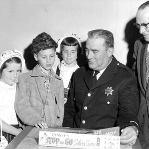 [Ann, Ellen and Rita Carrol, Robert Bertolina, Inspector Thomas Tracy and G. A. Rhodes discussing J. C. Penney's "Stop and Go Safety Game"]