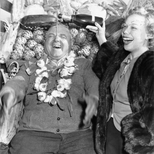 [Joan Edwards pouring champagne on top of Louis Petroni at the Farmers' Market on Alemany Boulevard]