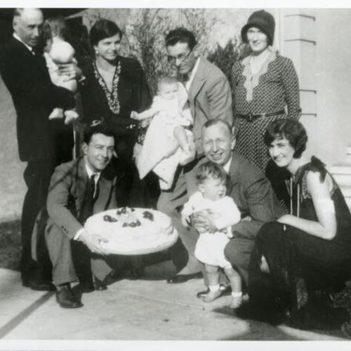 [First birthday party with family and birthday cake]