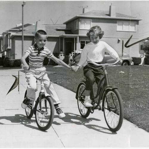 [Mark Kopache and Janis Johnson riding their bikes in the Lakeside district]