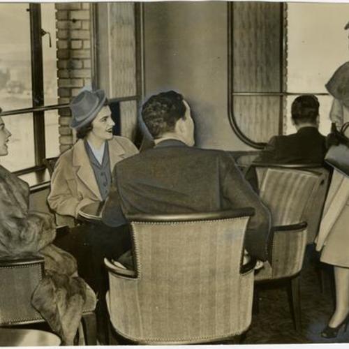 [Group of people sitting in the Sky Lounge of the Empire Hotel]