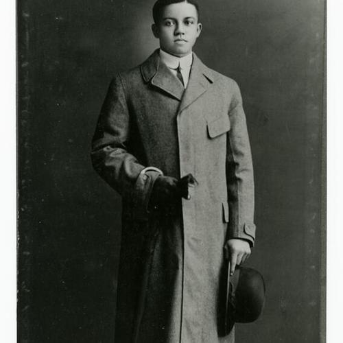 [Portrait of Alonzo as a young man at age 21 or 22 wearing a long coat and holding a hat between 1917 and 1918]