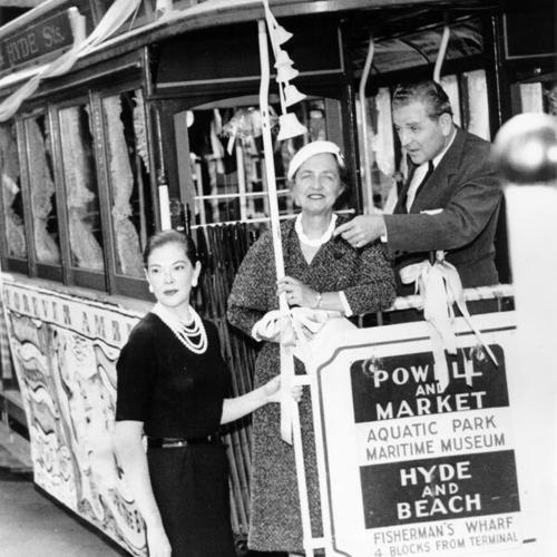 [Three people on a decorated cable car]