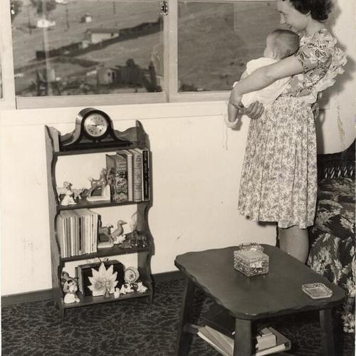 [Mrs. Barbara Corbin holding her daughter Judith Ann in their Hunters Point home]