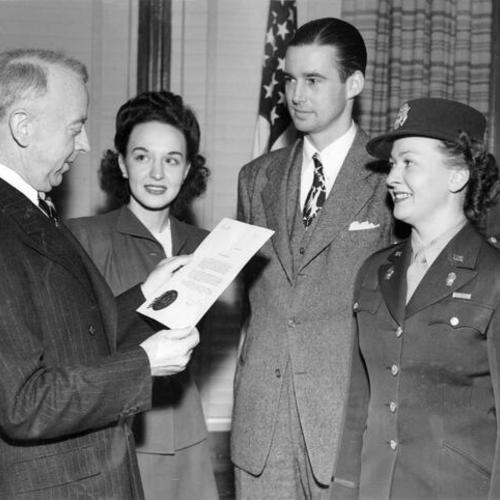 [Thomas Brooks hands Lieutenant Lillian Smoak of the Air WAC the proclamation of Mayor Angelo J. Rossi officially designating December 17 as Kitty Hawk Day in San Francisco]