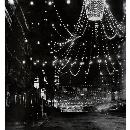 [Market Street at night, decorated for the 50th anniversary celebration of the discovery of gold]