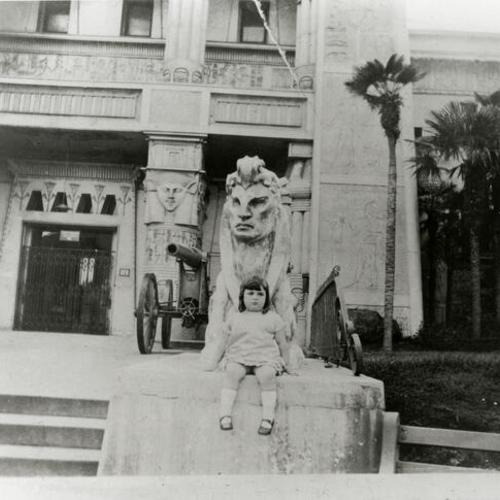 [Portrait of a little girl on steps of the old de Young Museum, artillery and sphynx statue at Golden Gate Park]