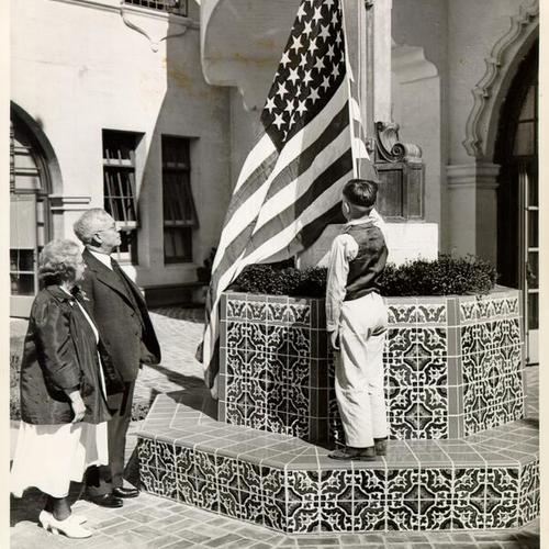 [Dr. Carrie Daly, Principal of Sunshine Orthopedic School, and Joseph P. Nourse, Superintendent of Schools, watching student Jack Miles salute the American flag in the courtyard of Sunshine School]