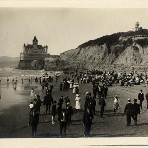 [Crowds of people congregating on Ocean Beach across from the Cliff House]