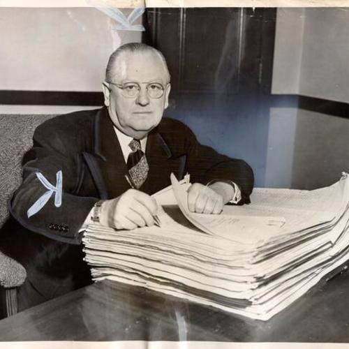 [Mayor Elmer E. Robinson sitting at his desk with part of the 1951-1952 city budget]