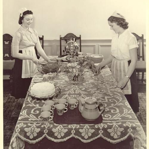 [Maxine Swarty and Betty Mae Laskey preparing table at Girls High School]