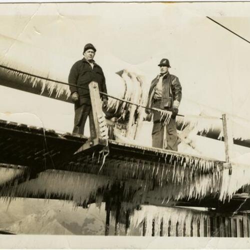 [Golden Gate Bridge workers examine ice on bridge]