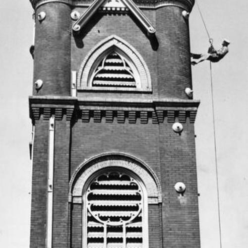 [Steeplejack Ralph Clark suspending from the steeple of St. Mark's Lutheran Church]