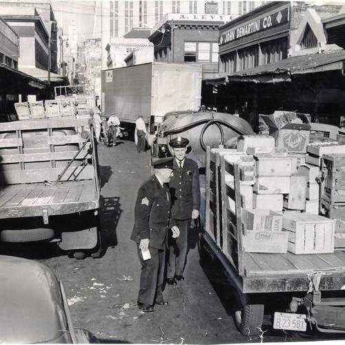[Two policemen issuing tickets to produce delivery trucks at Washington and Front streets]