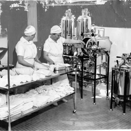 [Hahnemann Hospital nurses Betty Rogers and Mary Brower examine sterilization equipment]