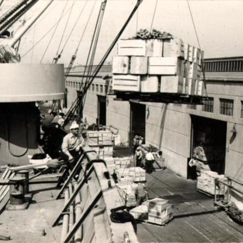 [Shipment of fruits and vegetables being loaded onto a ship at the San Francisco waterfront]