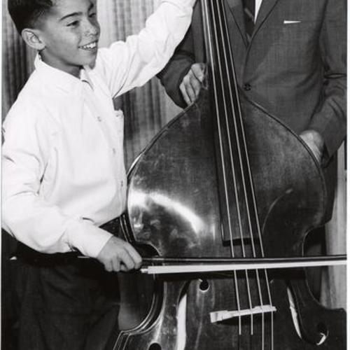 [Dr. Harold Spears, Superintendent of Schools, watching a student play a cello at John Swett Elementary School]